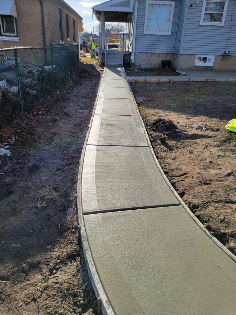 A concrete walkway is being built in front of a house.