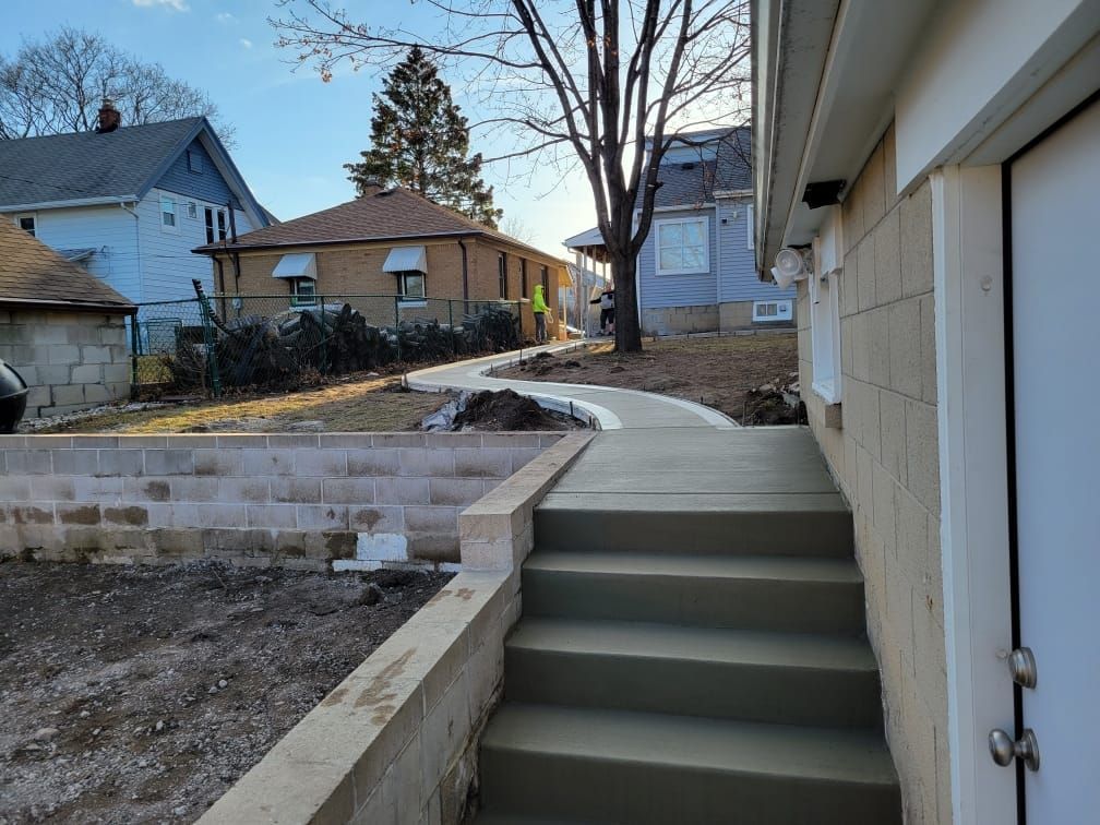 A concrete walkway with stairs leading to a house