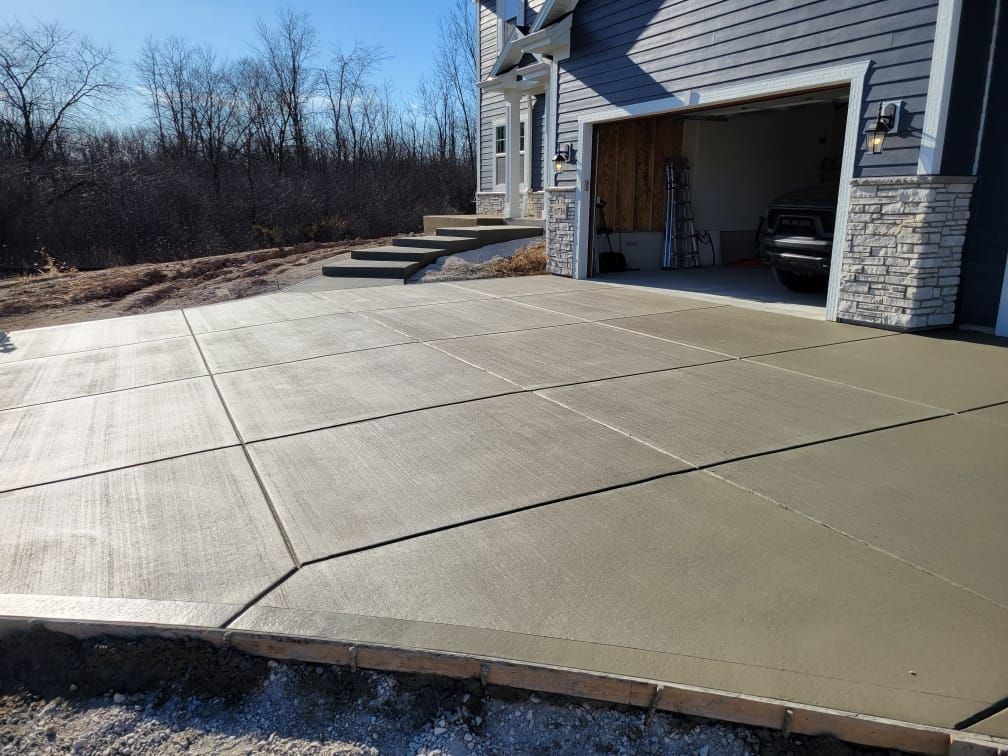 A concrete driveway is being built in front of a house.