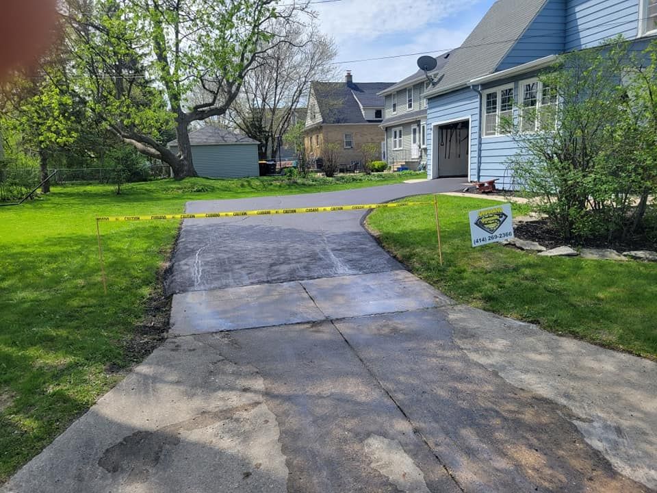 A driveway is being paved in front of a house.