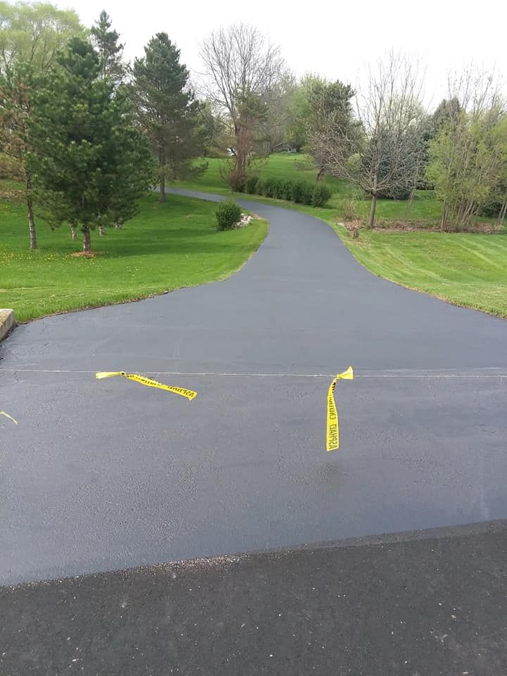 A black road with a yellow tape on the side of it.