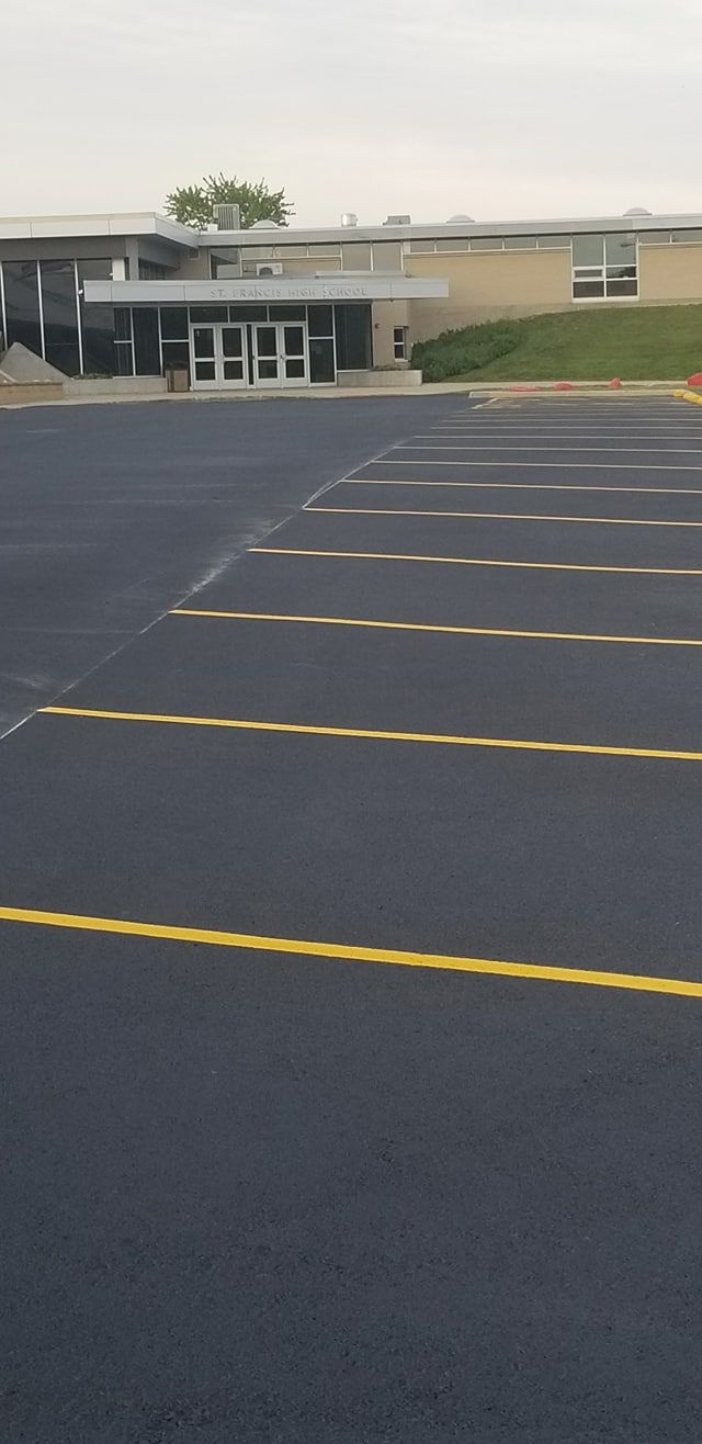 A parking lot with yellow lines and a building in the background