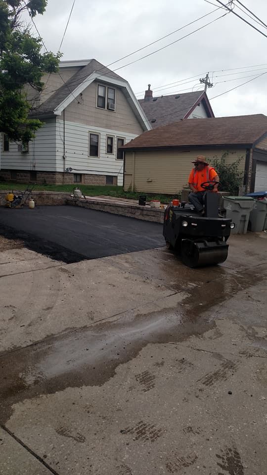 A man is riding a roller on a road in front of a house.