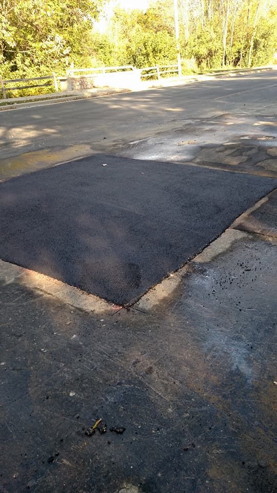 A large piece of asphalt is sitting on the side of a road.