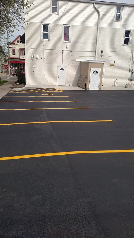 A parking lot with yellow lines in front of a building.