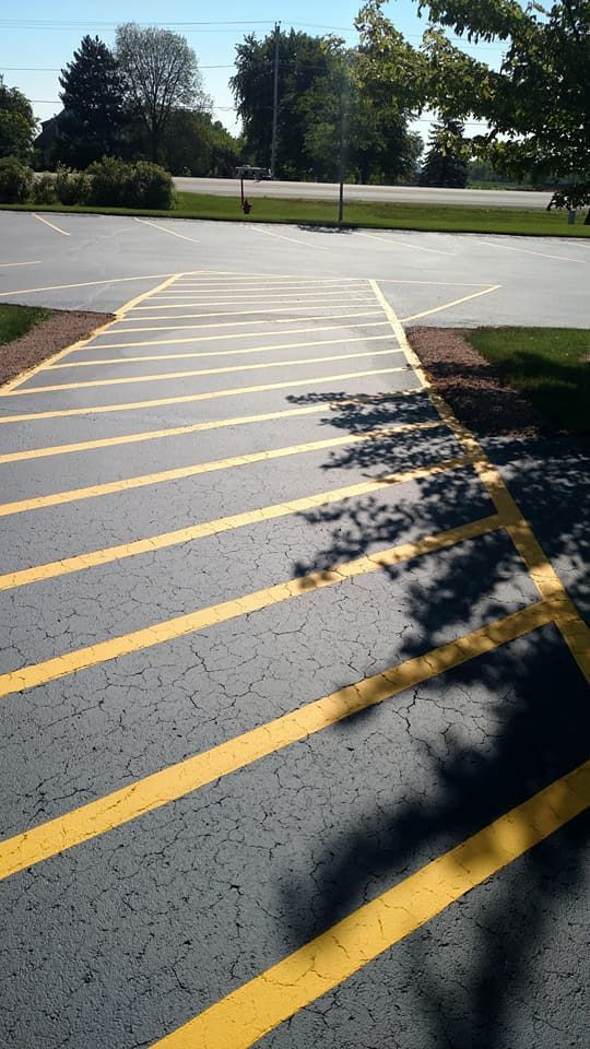 A parking lot with yellow lines and trees in the background
