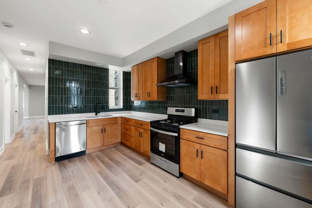 A kitchen with wooden cabinets and stainless steel appliances.