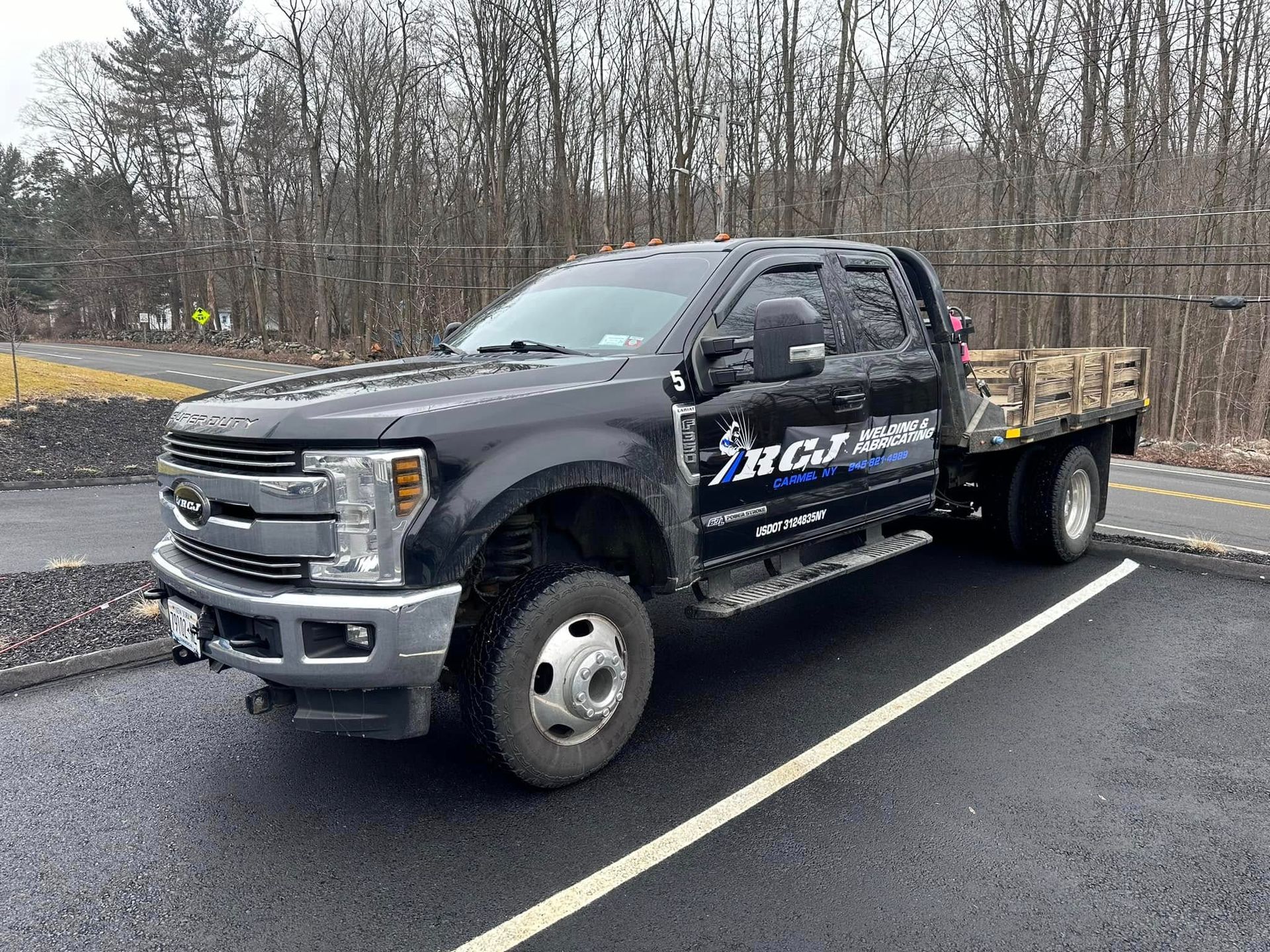 Black flatbed truck parked in a lot; 