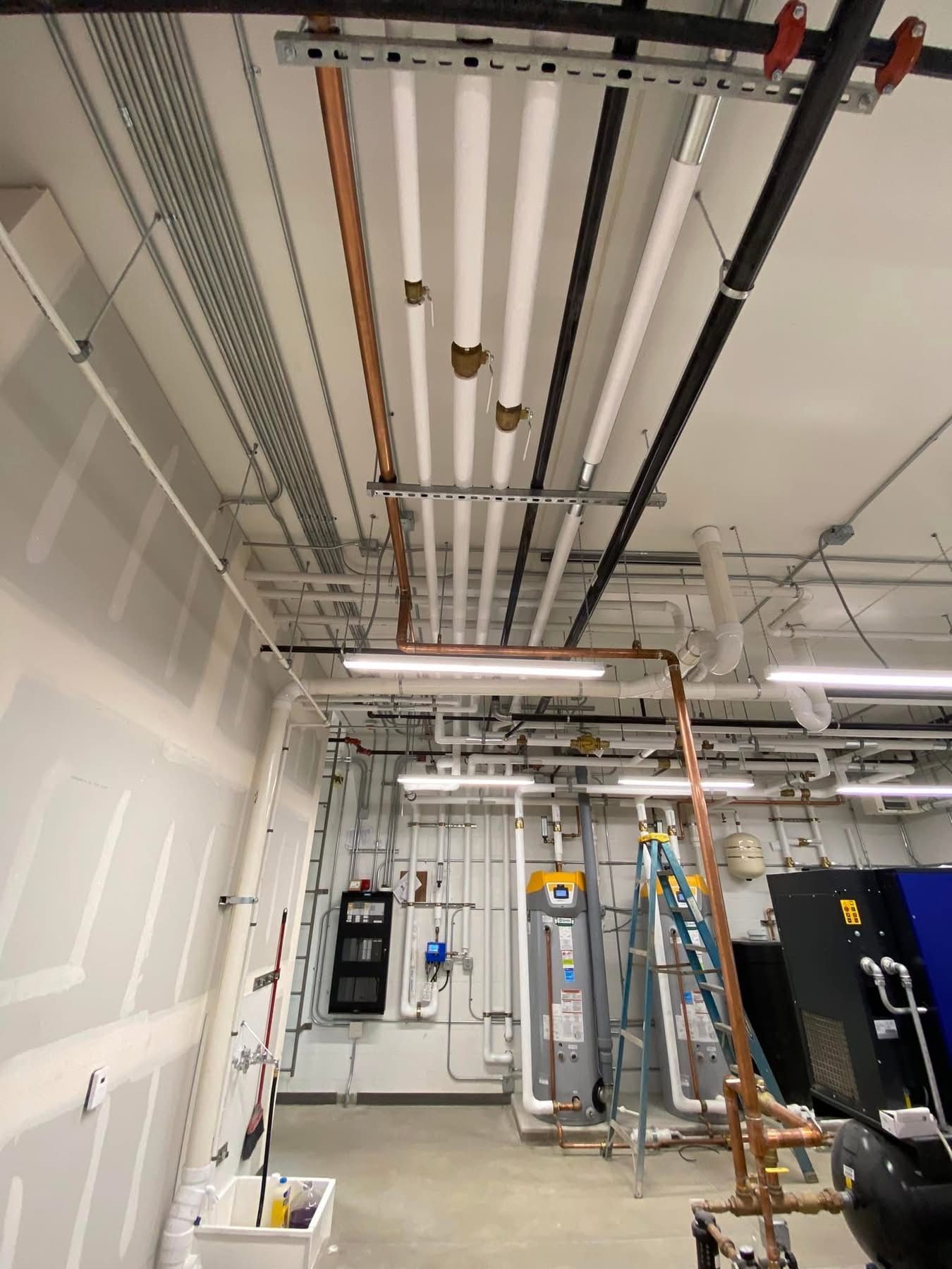 A room with a lot of pipes hanging from the ceiling