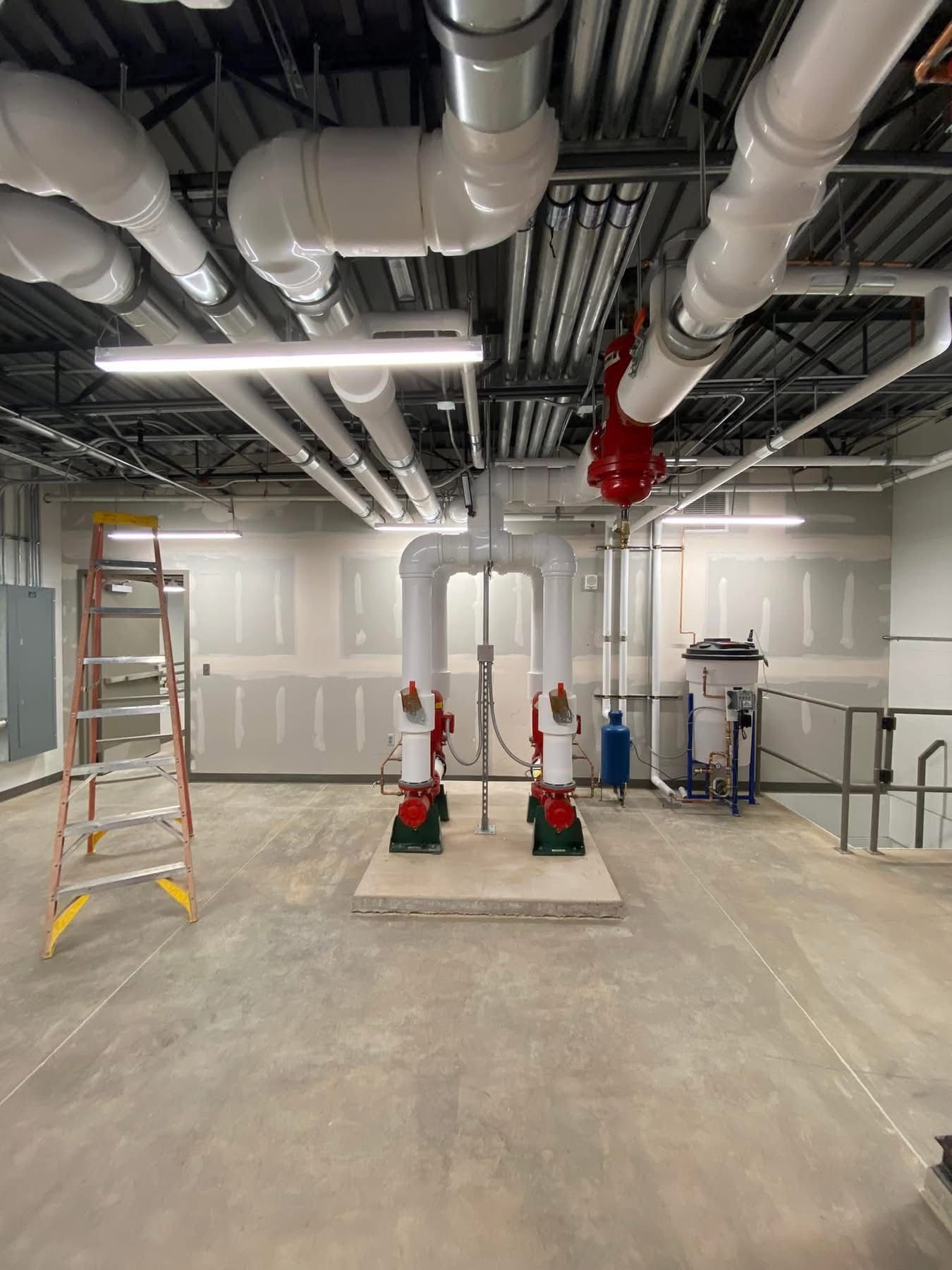 A large room with a lot of pipes hanging from the ceiling.