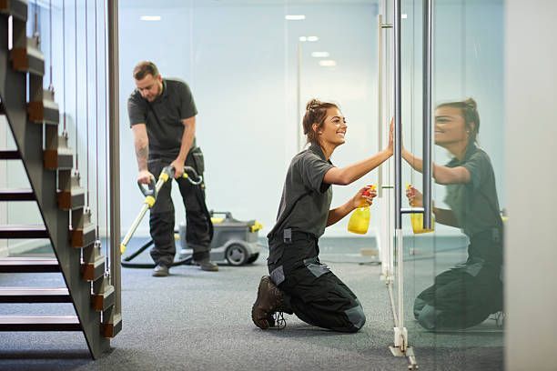A man and a woman are cleaning a building.