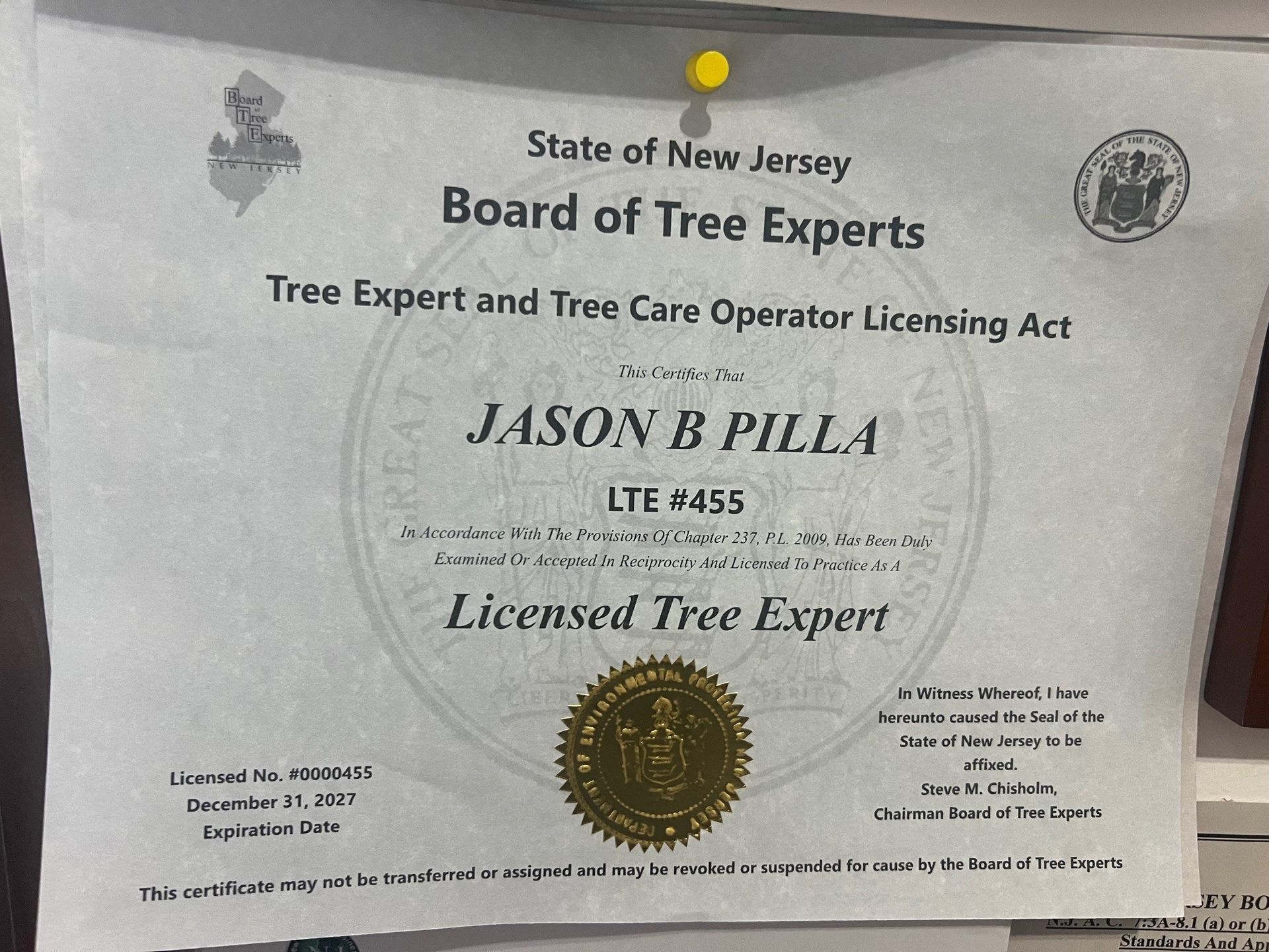 New Jersey licensed tree expert certificate of Jason B. Pilla, with a gold seal and pinned to a wall.