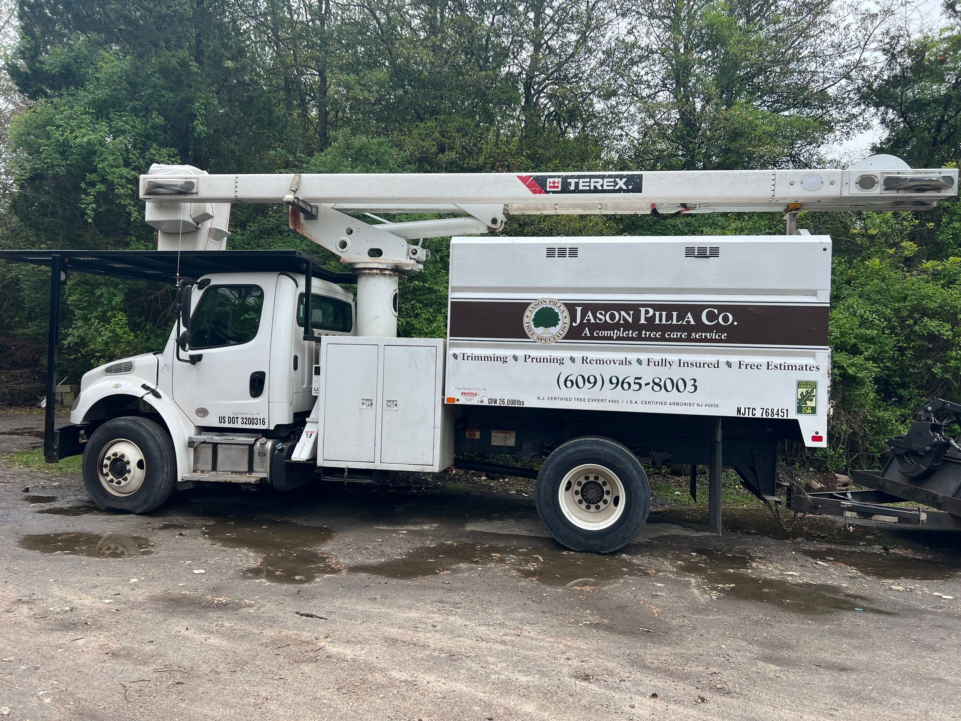 White tree service truck with extended boom, 