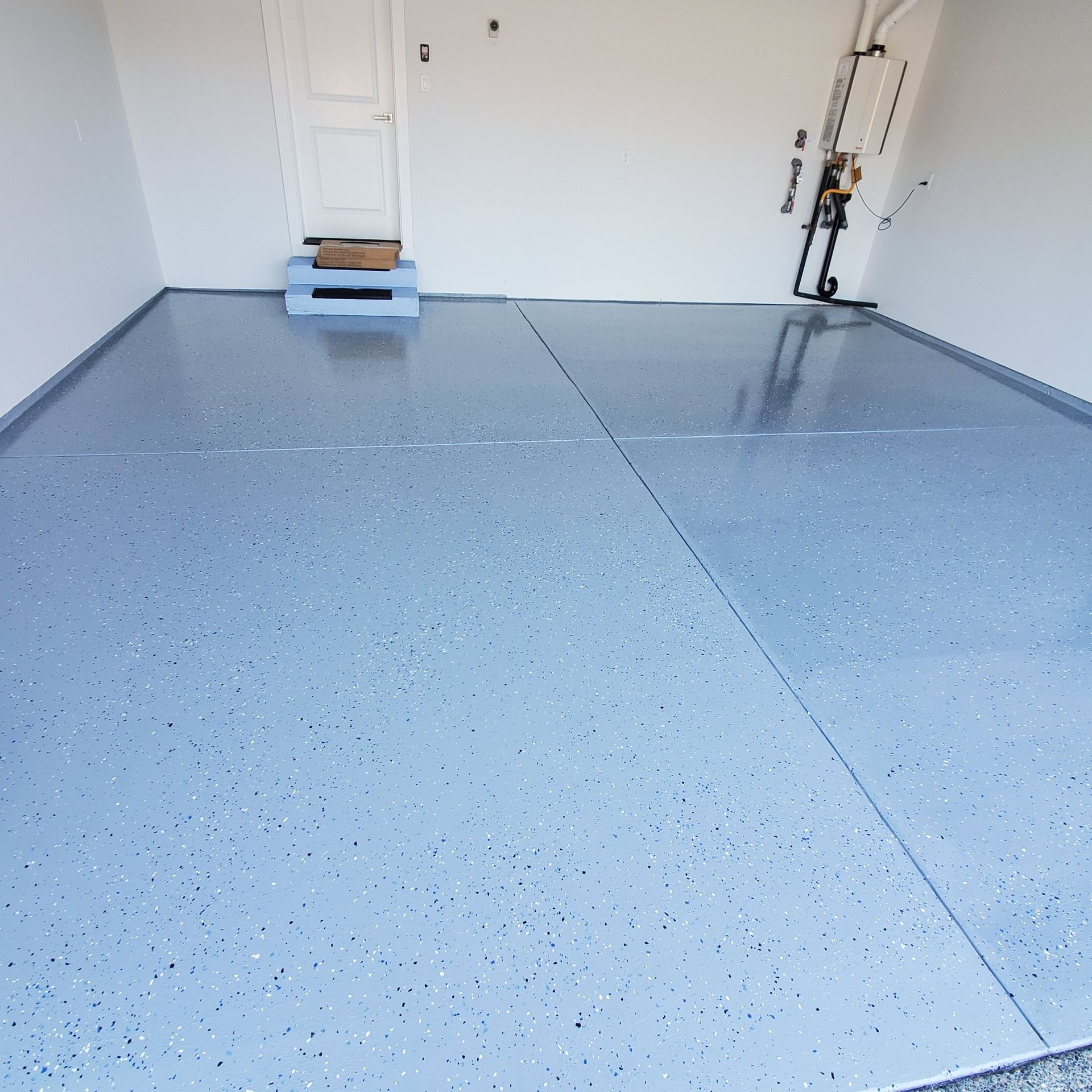 Garage with a glossy, speckled blue-gray epoxy floor and white walls.