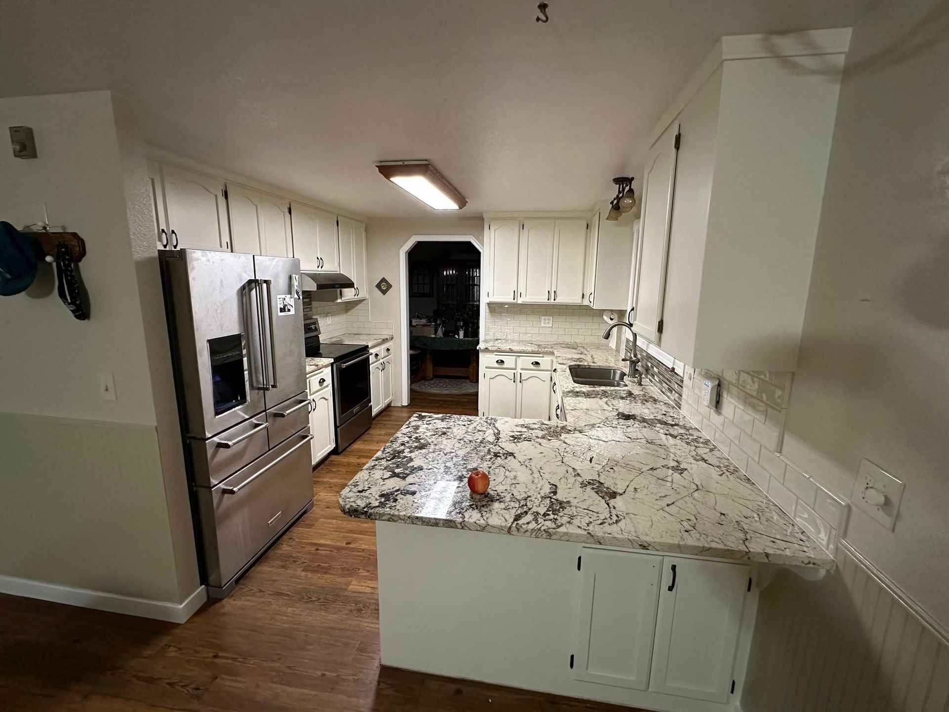 Kitchen with white cabinets, granite countertops, and stainless steel appliances.
