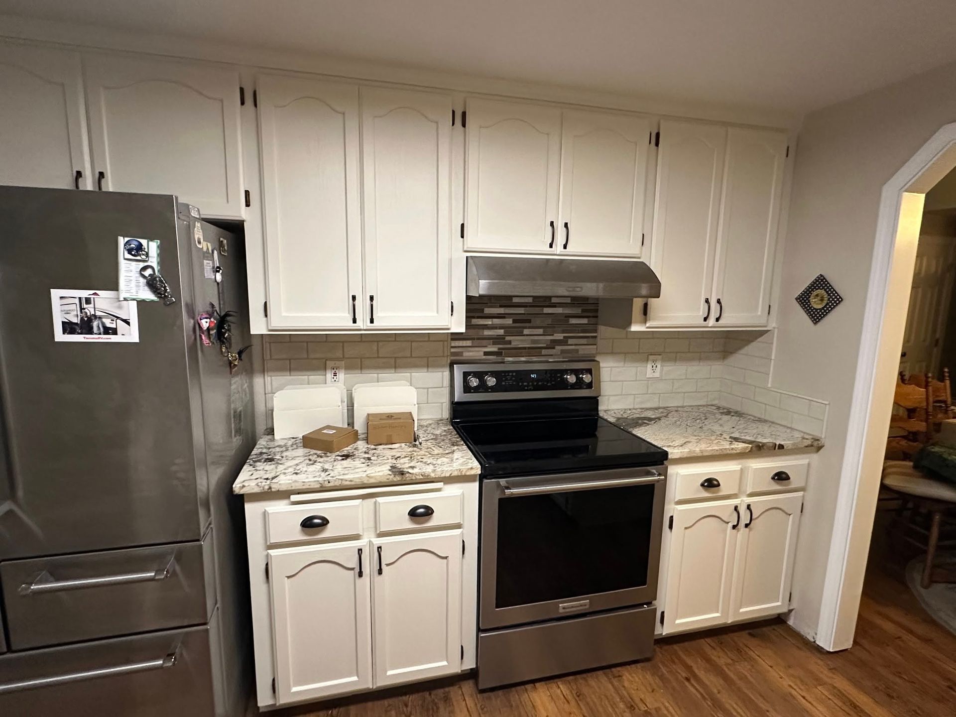 Kitchen with white cabinets, stainless steel appliances, and granite countertops.