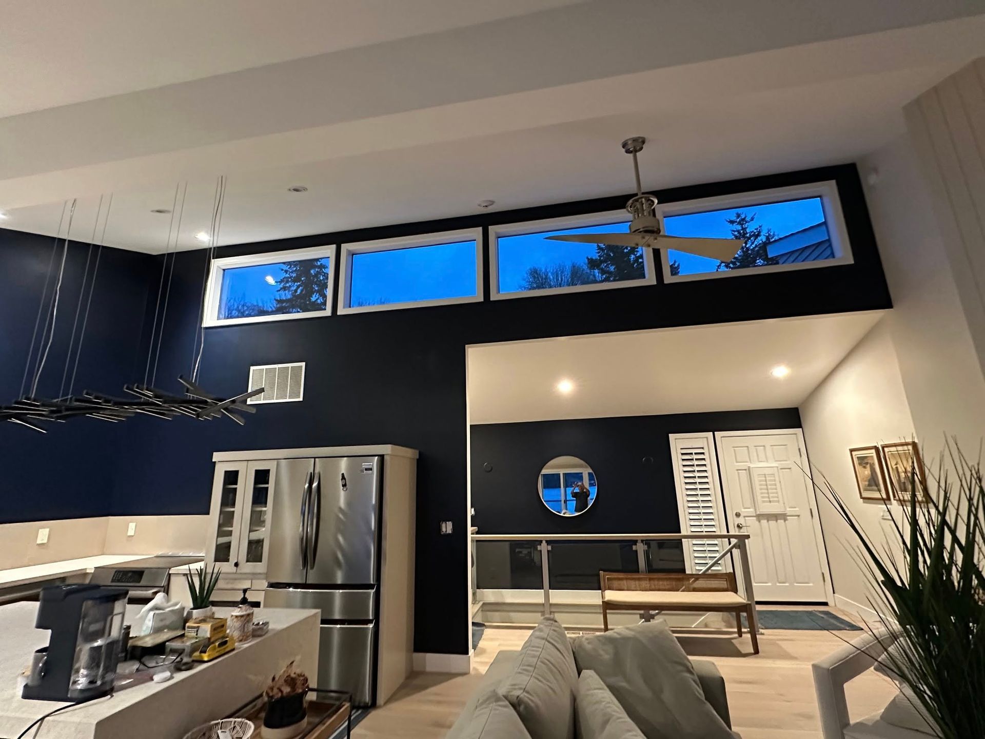 Modern interior with dark blue walls, clerestory windows, kitchen, and living room.