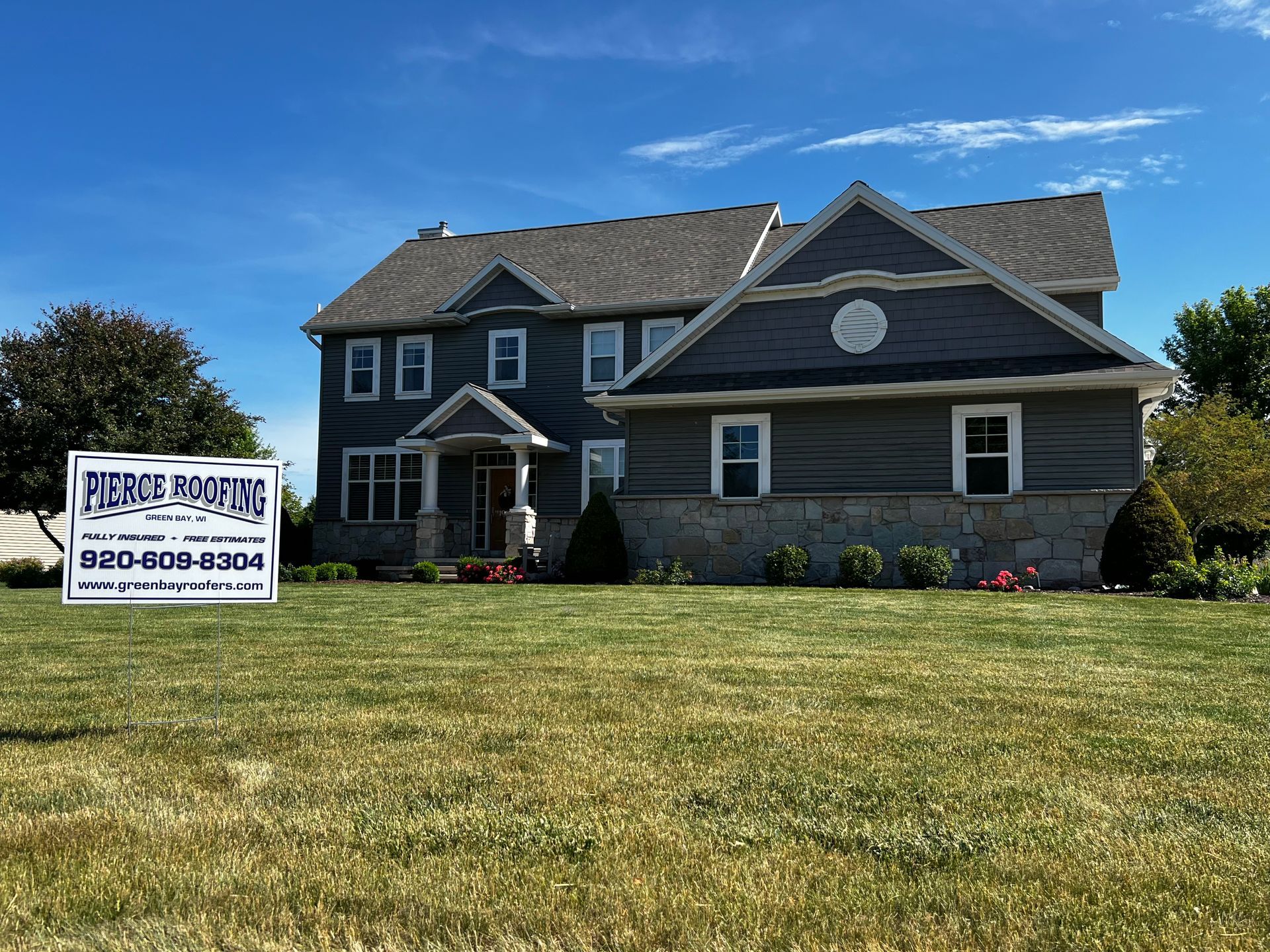 A large house with a for sale sign in front of it.