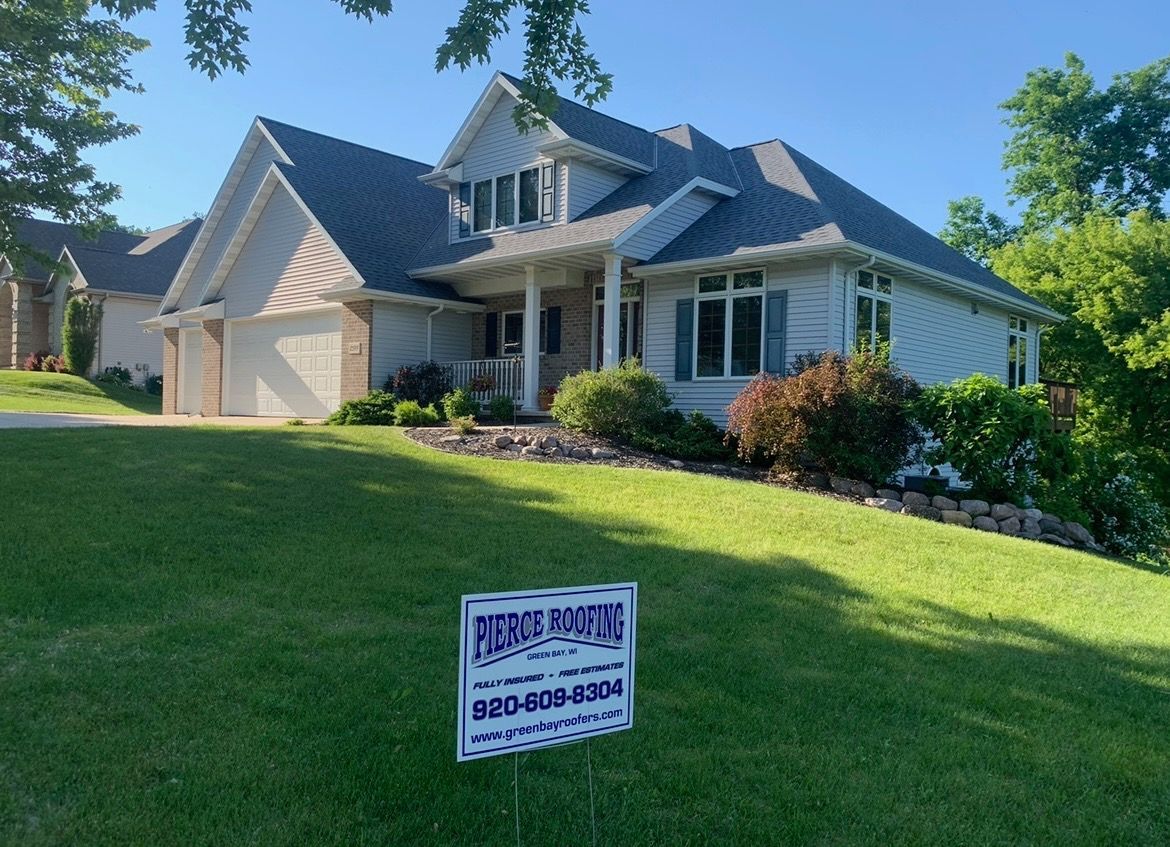 A large white house with a sign in front of it.