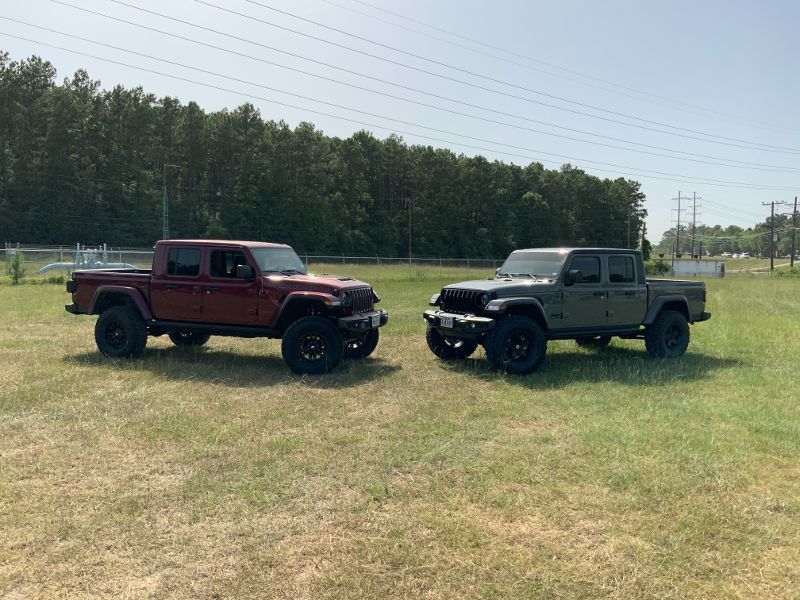 Two trucks are parked next to each other in a field.
