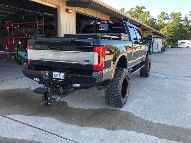 A black truck is parked in front of a garage.