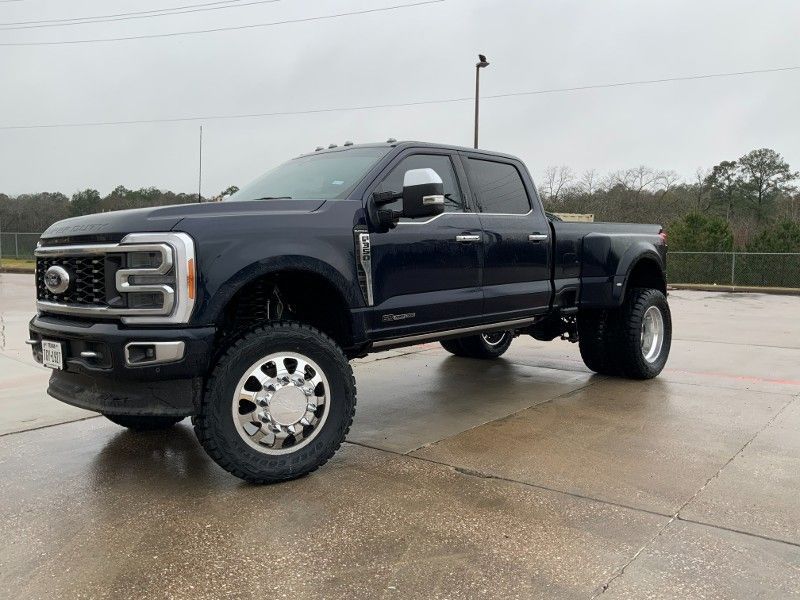 A black ford truck is parked on the side of the road.