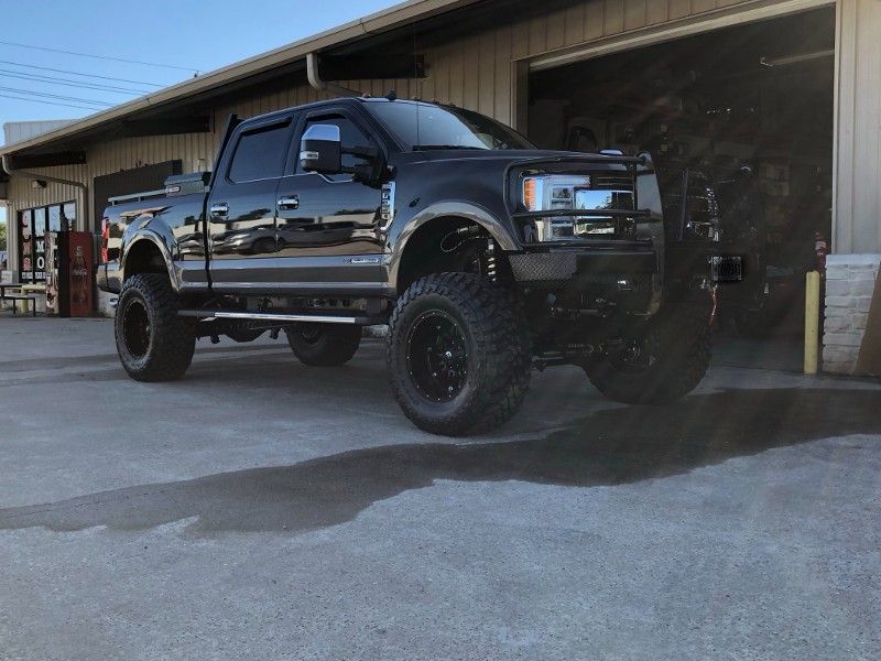 A black truck is parked in front of a garage.