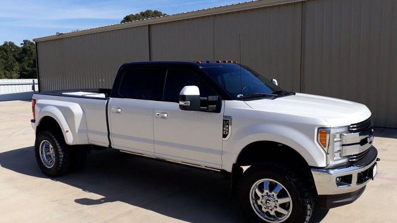 A white pickup truck is parked in front of a building.