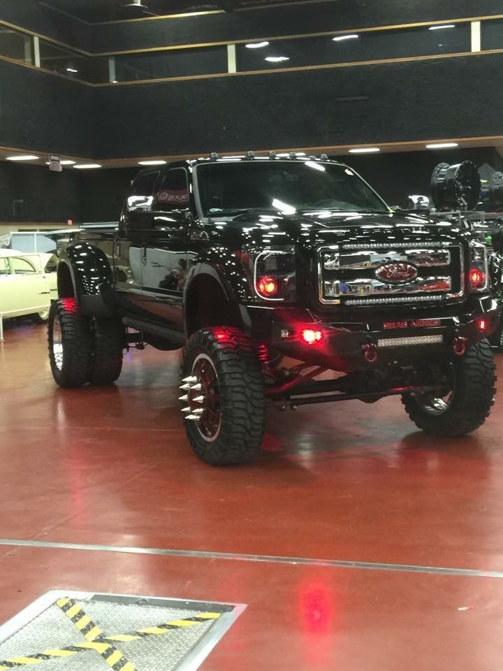 A black ford truck is parked in a garage