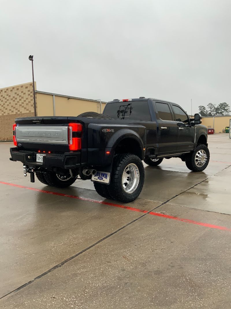A black truck is parked in a parking lot.
