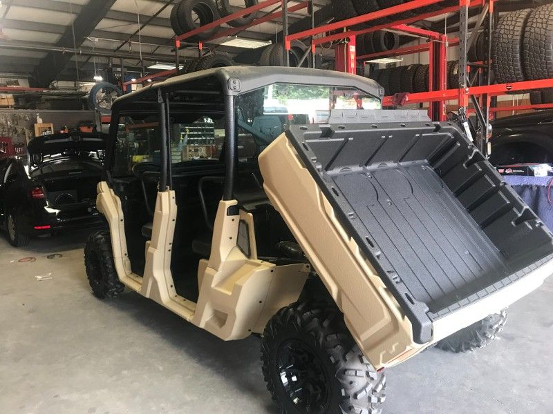 A utility vehicle is parked in a garage with the back door open