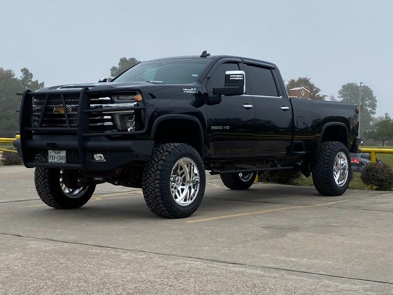 A black truck is parked in a parking lot.