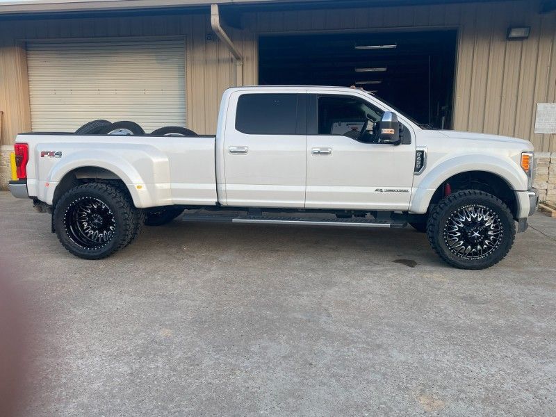 A white pickup truck is parked in front of a building.