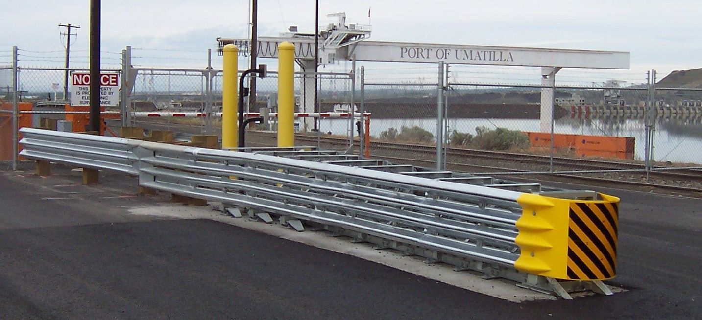 A metal barrier with a yellow stripe on the side of it