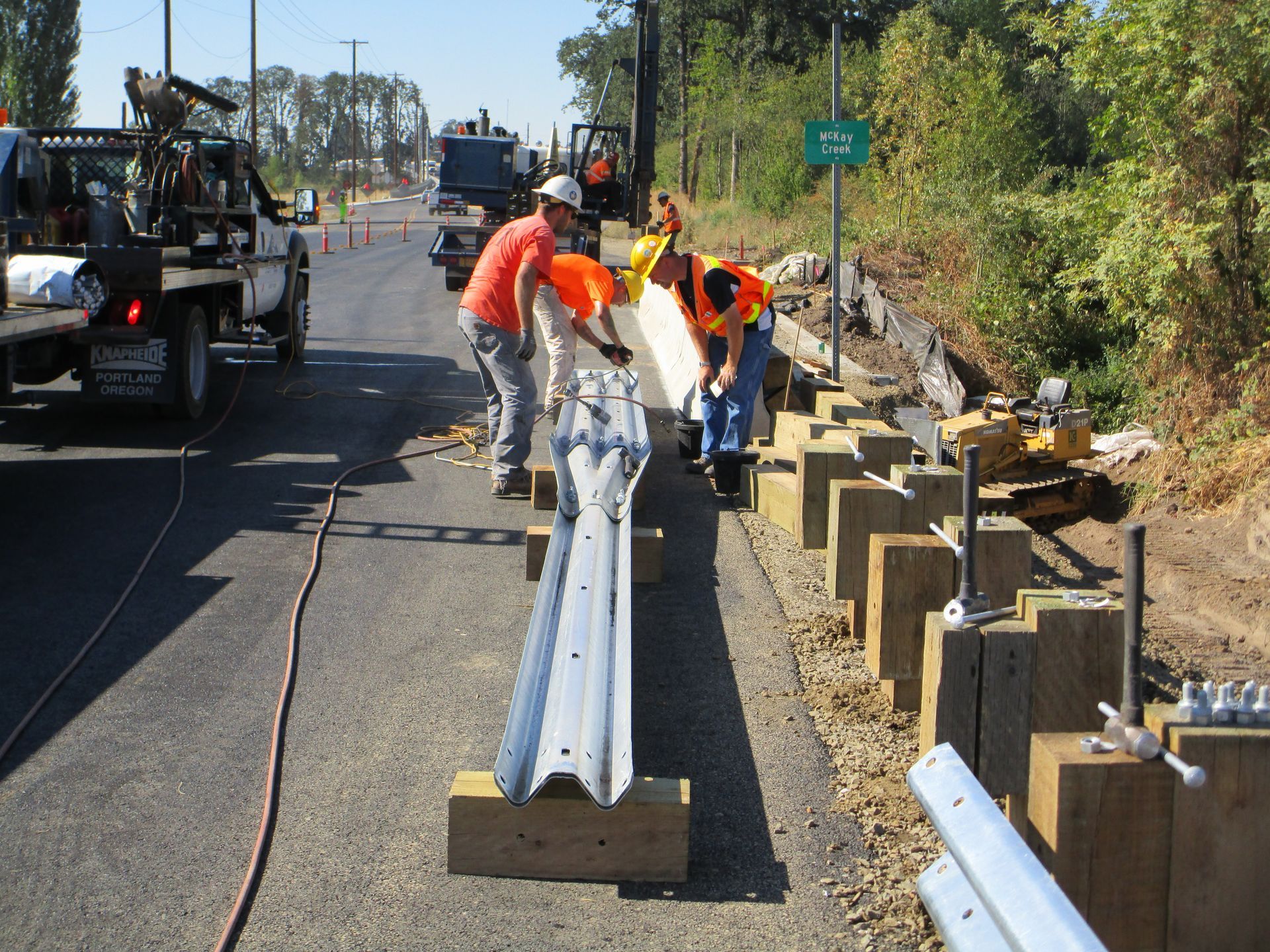 A group of construction workers are working on a road