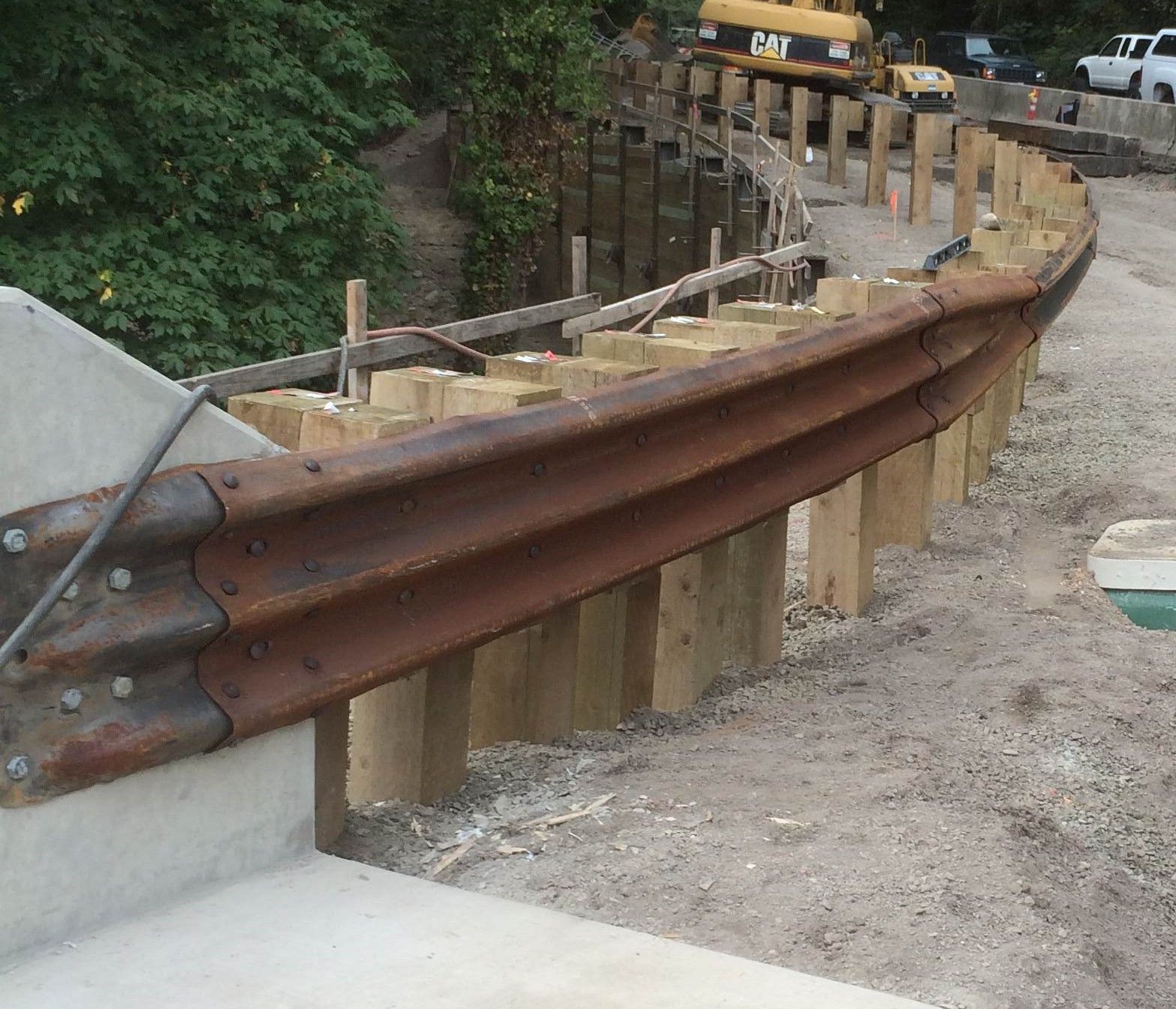 A rusty metal railing is surrounded by wooden posts