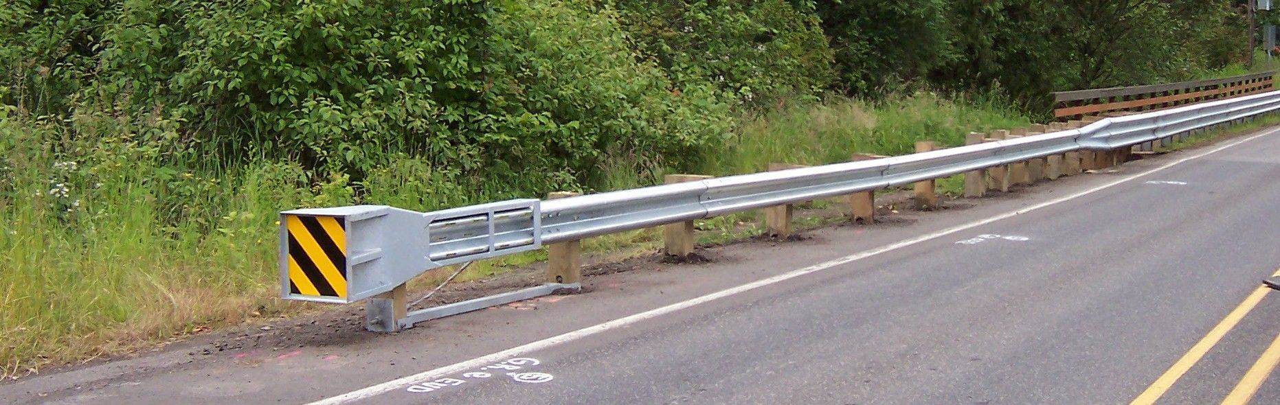 There is a metal railing on the side of the road.