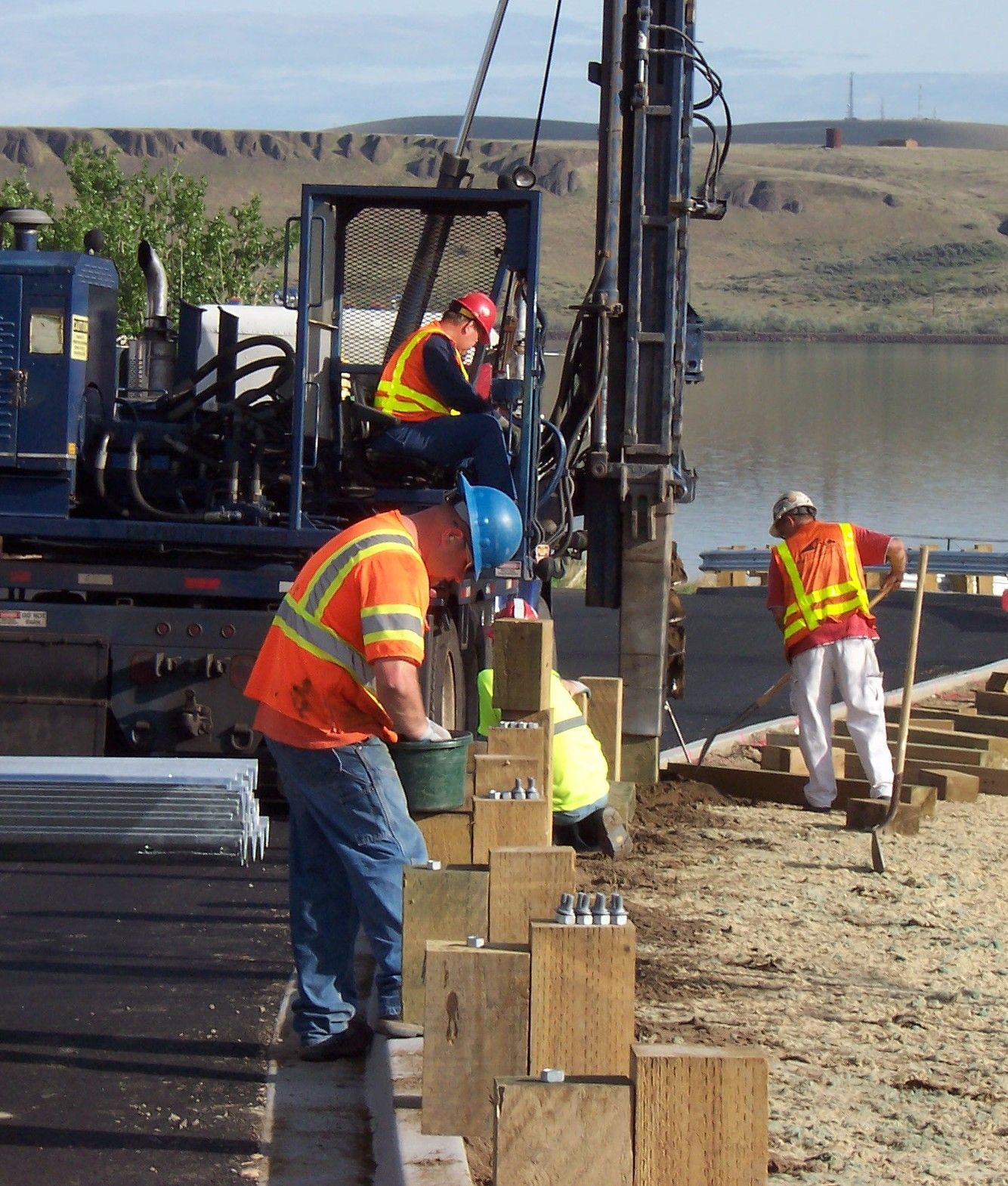 A group of construction workers are working on a project near a body of water
