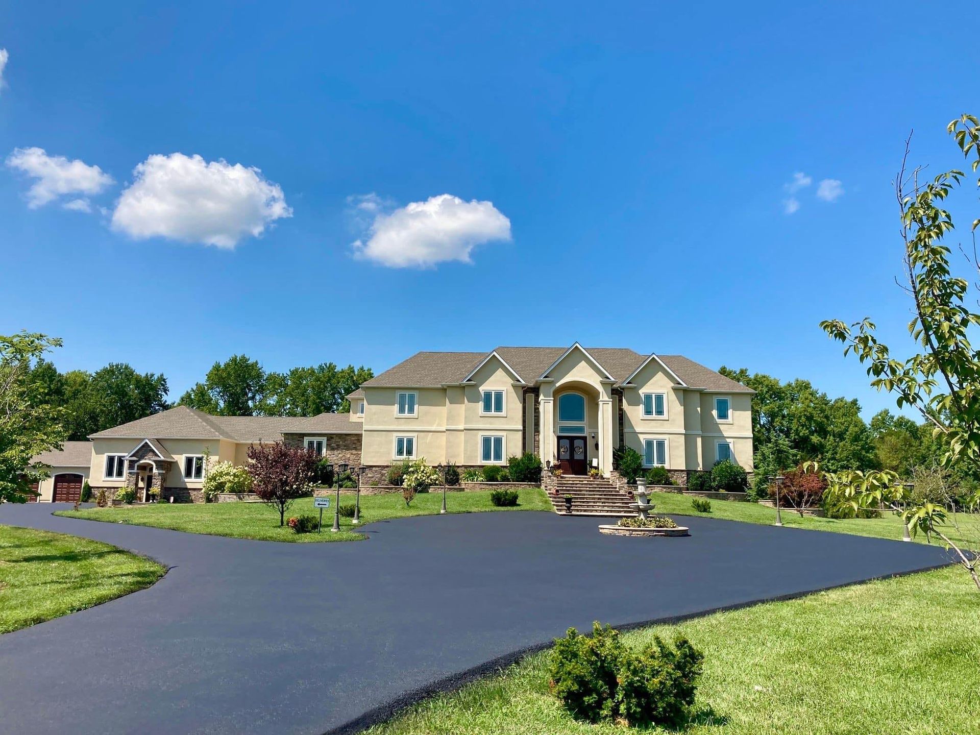 A large house with a large driveway in front of it.