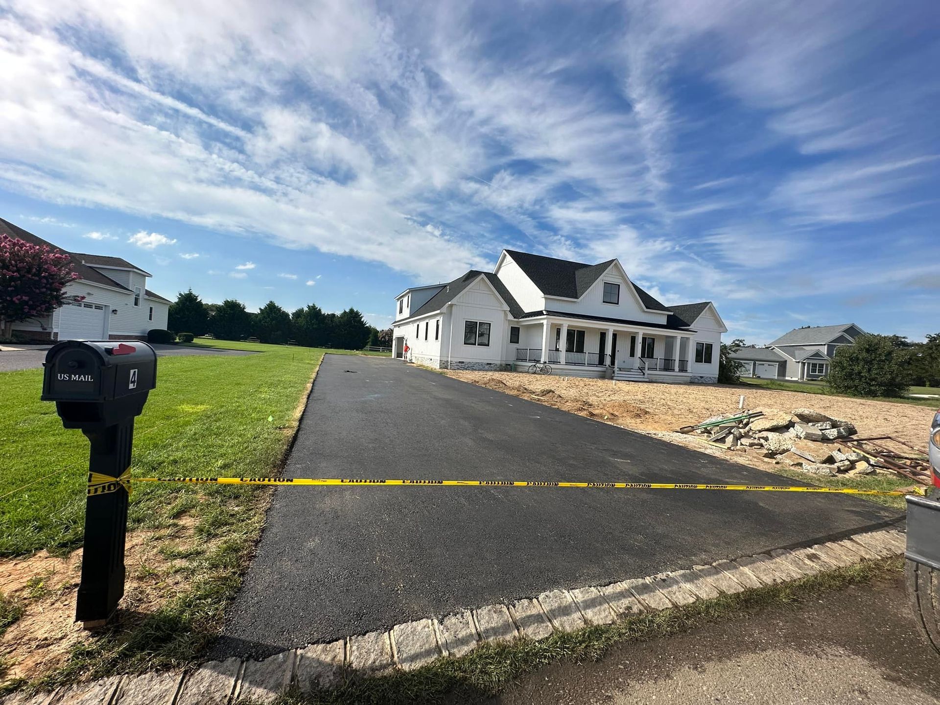 A large white house is being built in a residential neighborhood.