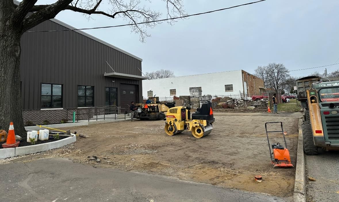 A construction site with a lot of machinery in front of a building.