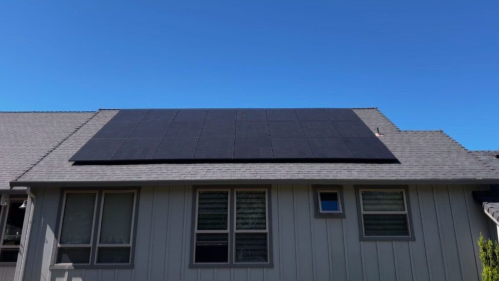 Solar panels installed on a residential roof against a blue sky.