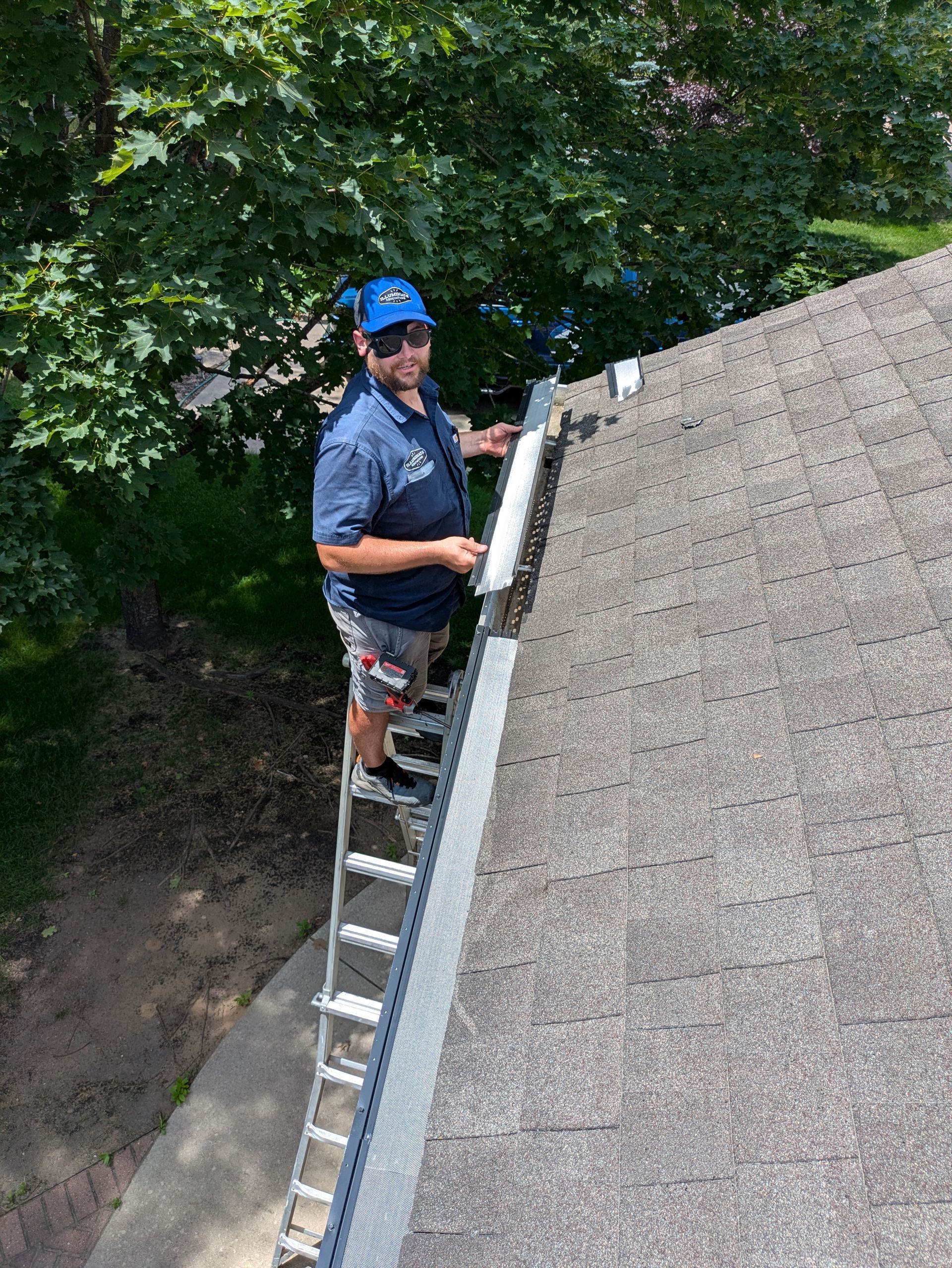 A man is standing on a ladder on top of a roof.