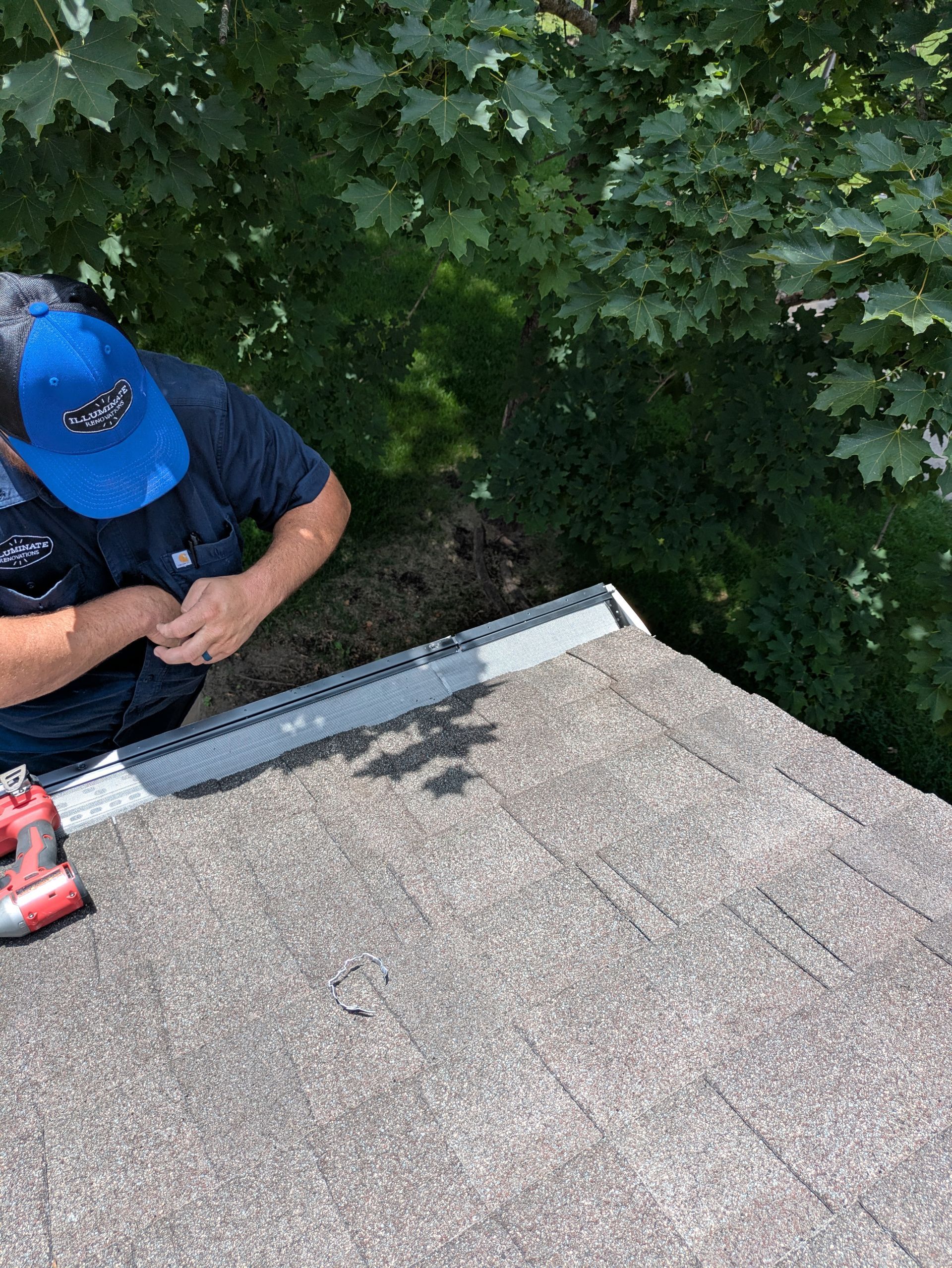 A man in a blue hat is working on a roof.