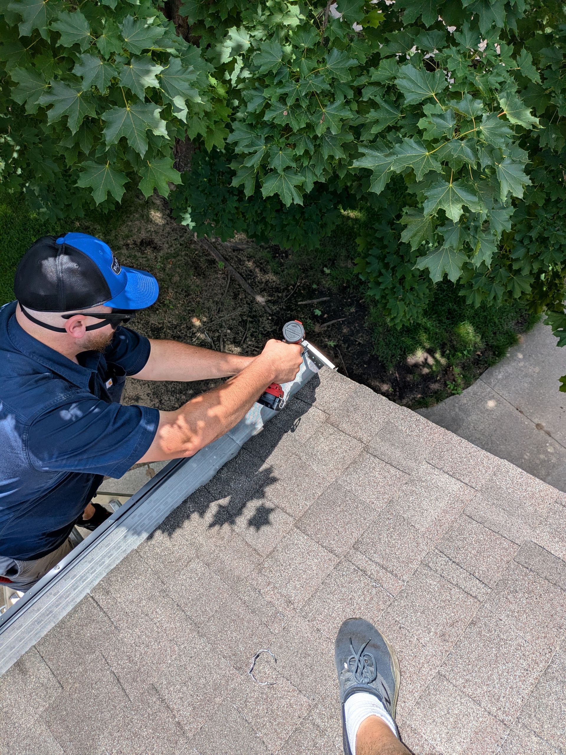 A man is working on a roof with a hammer.