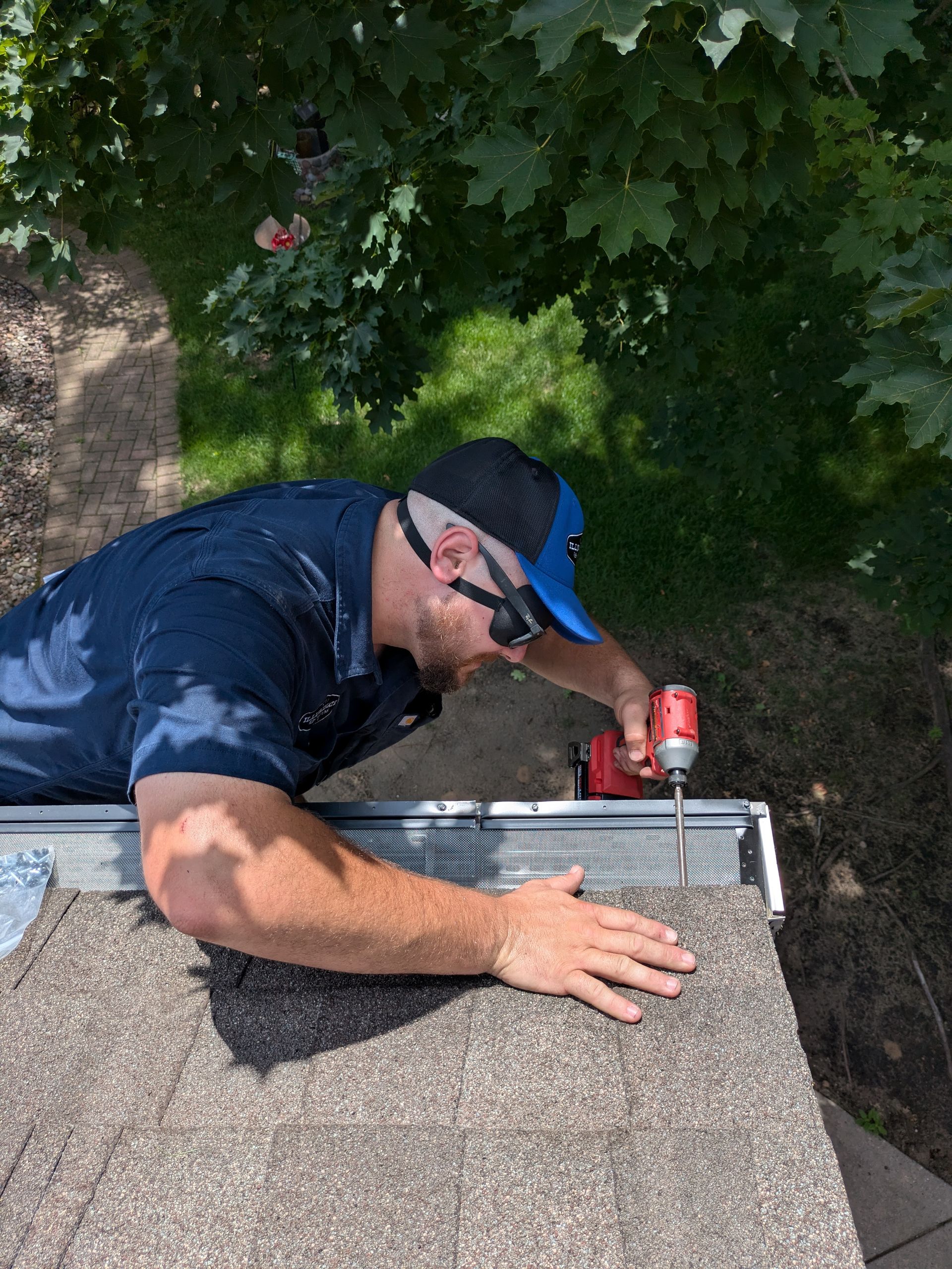 A man is working on a roof with a drill.