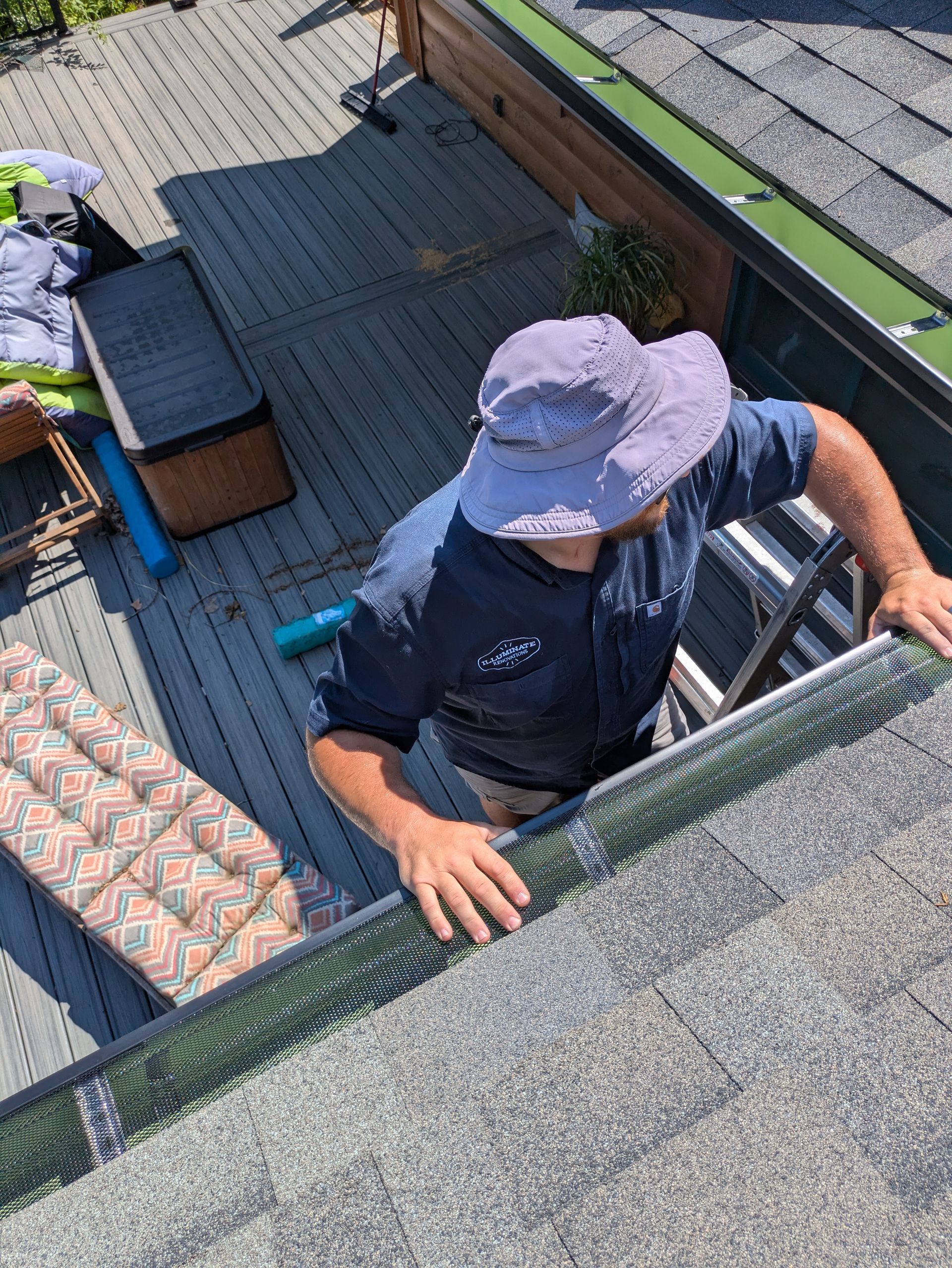 A man is standing on a ladder on top of a roof.