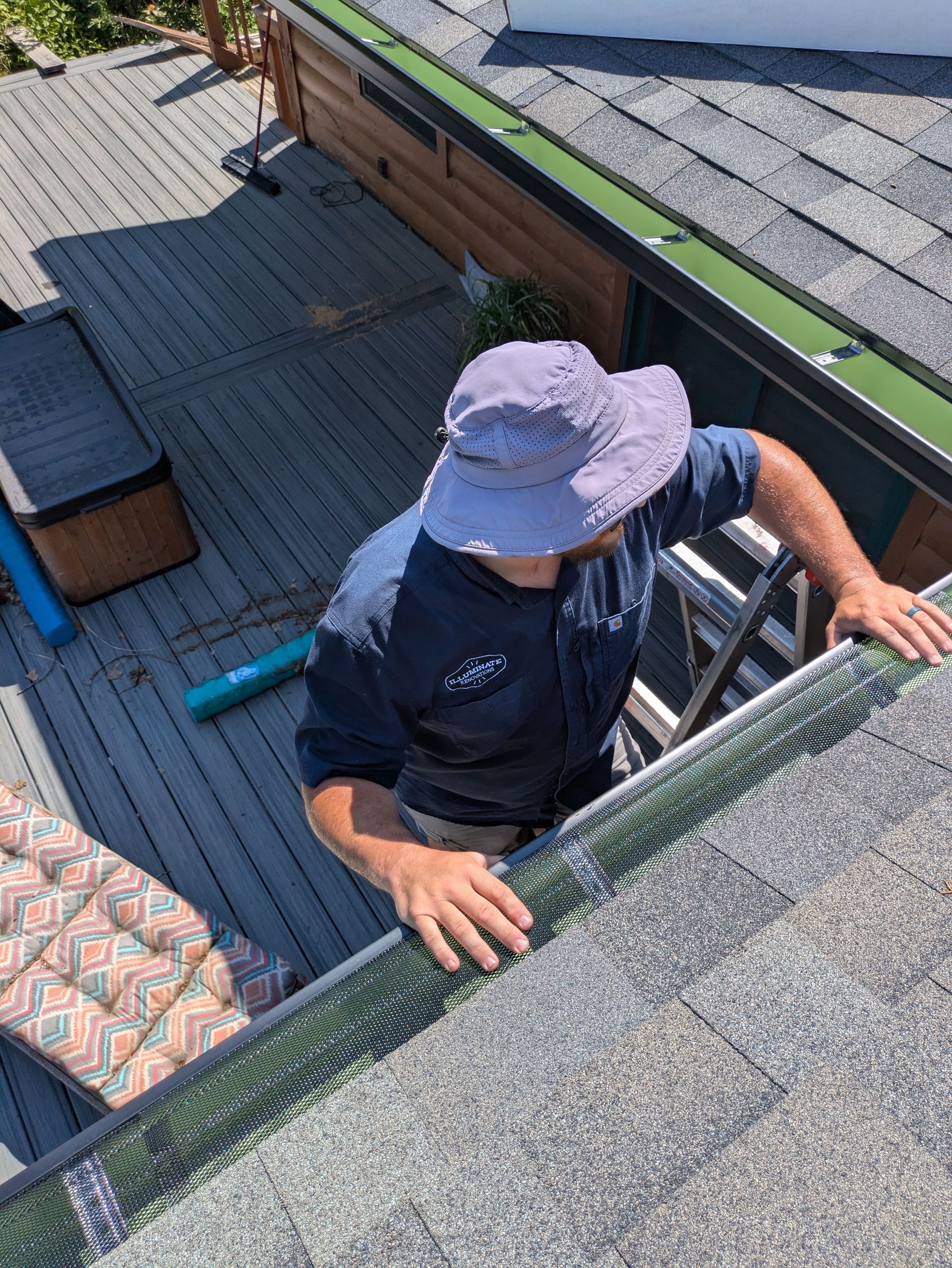 A man is standing on a ladder on top of a roof.