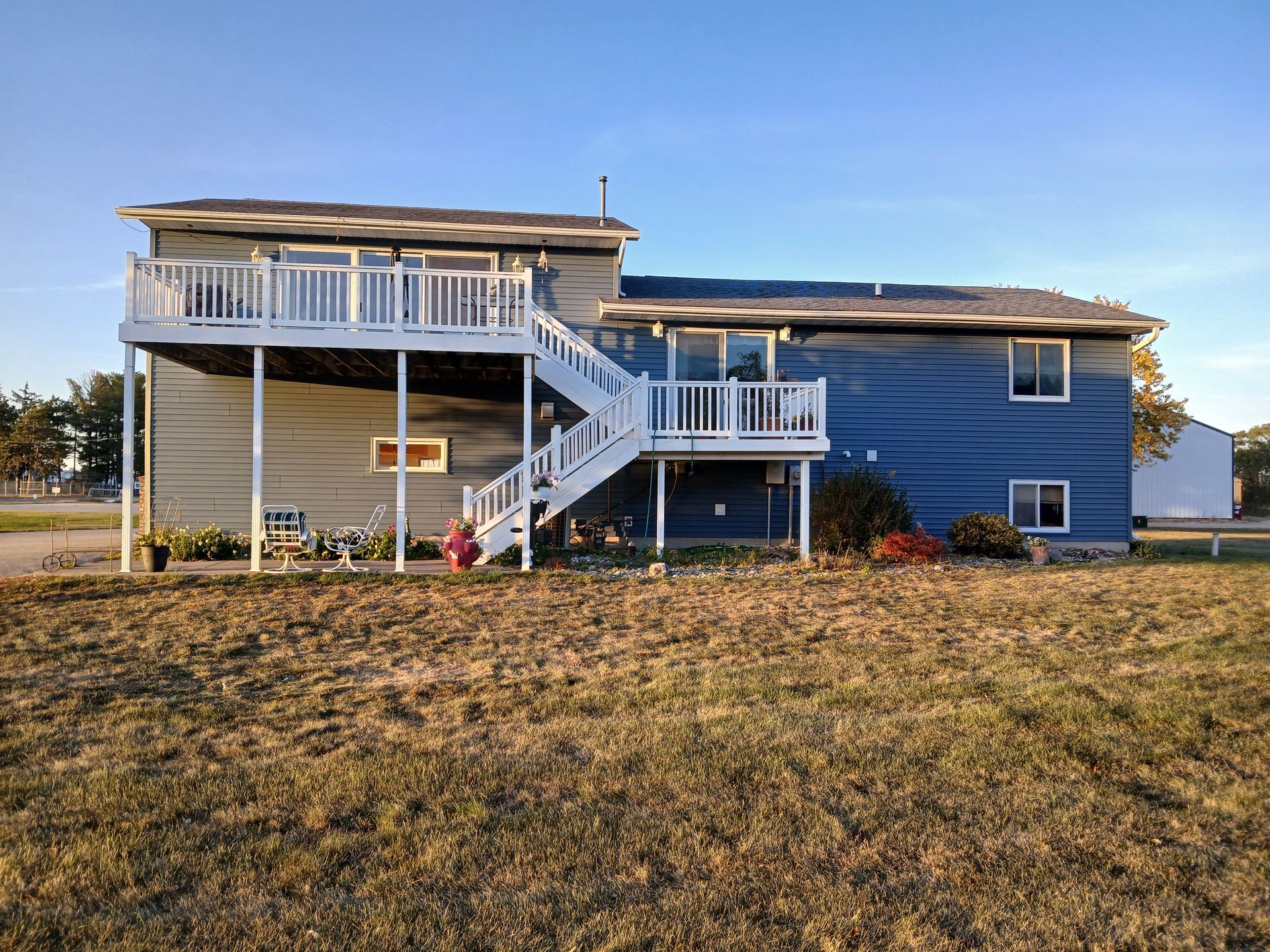 The back of a house with a large deck and stairs.