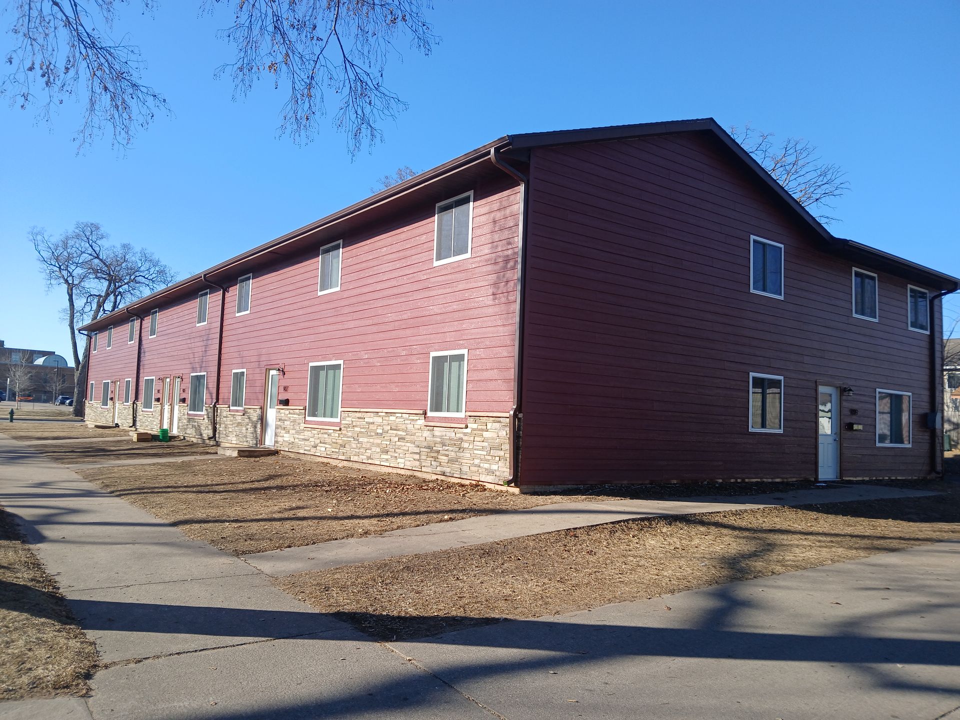 A red apartment building with a blue sky in the background